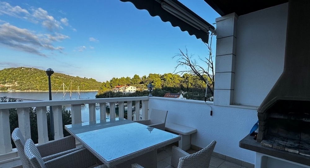 Terrazza con vista mare, tavolo da pranzo e grill