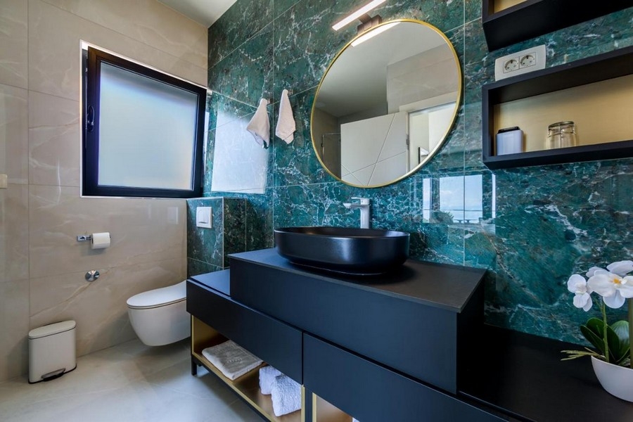 Bagno con lavabo nero ed eleganti dotazioni