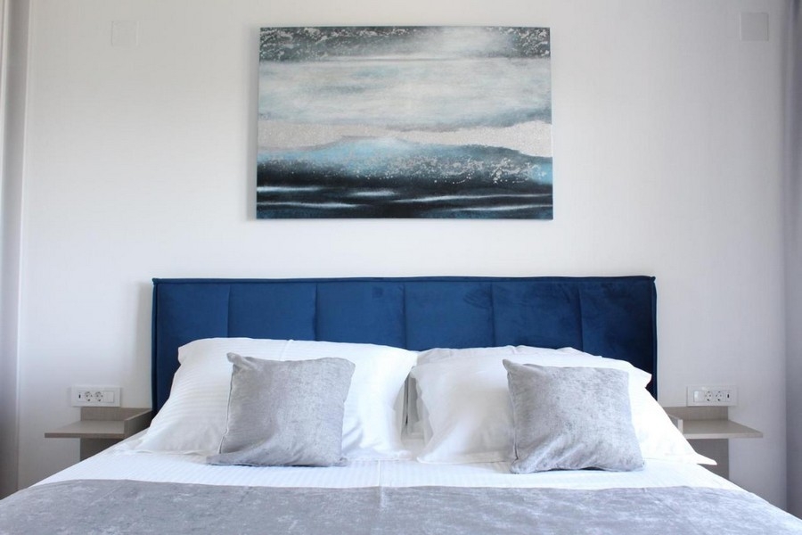 Letto matrimoniale nella camera da letto moderna con quadro decorativo alla parete