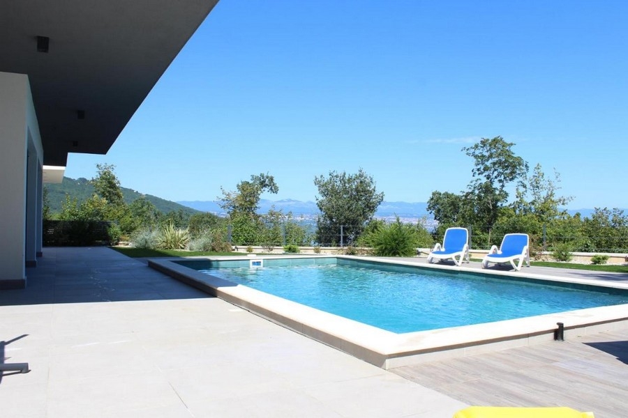 Area piscina con lettini e vista sul verde