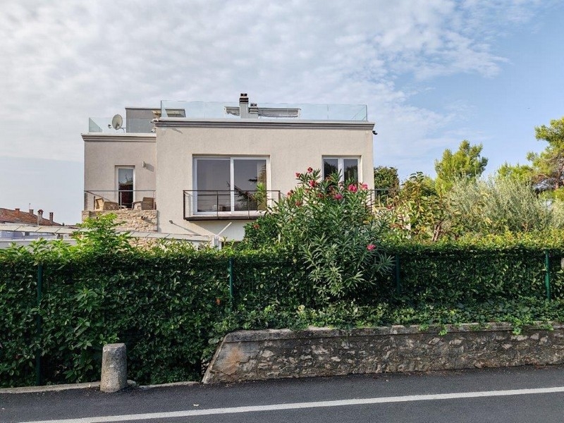 Villa moderna con balcone e recinzione curata