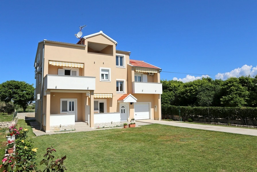Casa color albicocca con tende da sole e garage sul prato