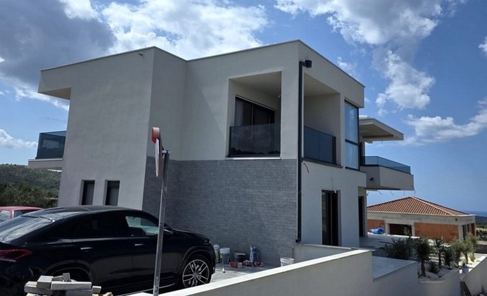 Angolo della casa con rivestimento in pietra naturale e posto auto in costruzione