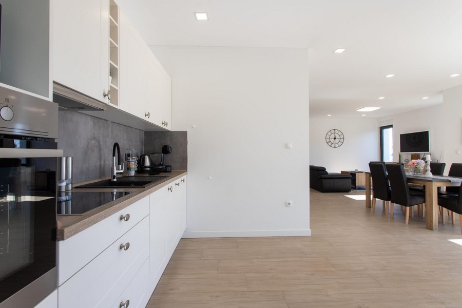 Cucina lineare bianca con vista sulla zona pranzo