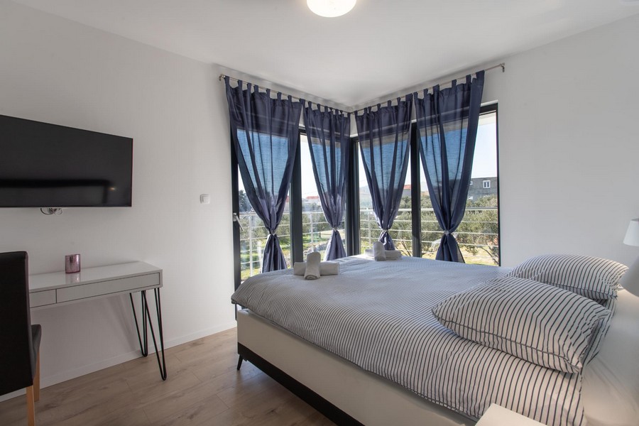 Camera da letto con tende blu alla finestra d'angolo