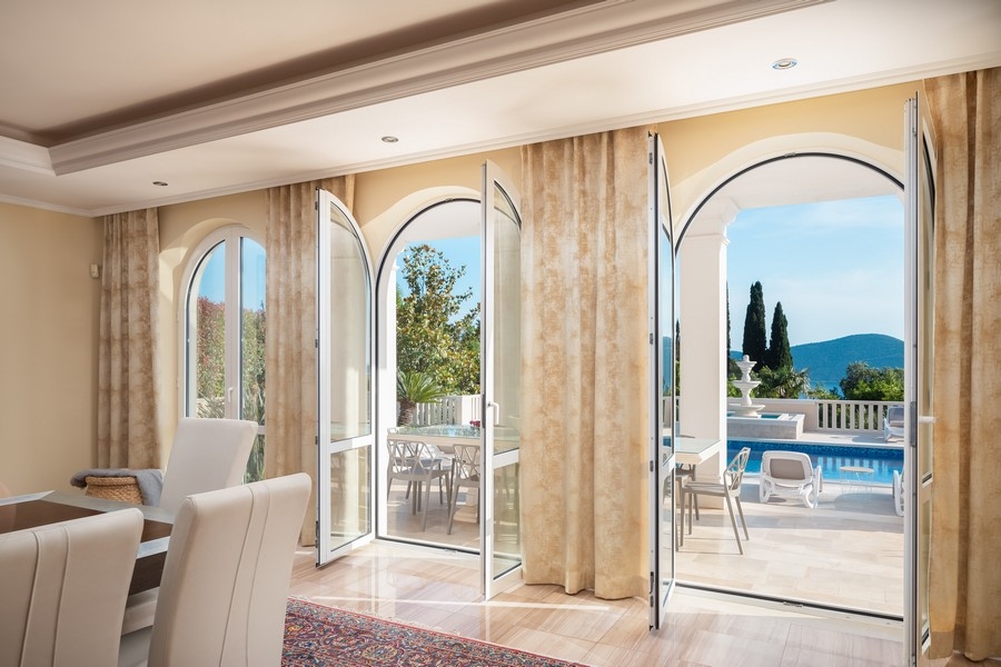 Zona giorno con grandi finestre e vista sulla piscina
