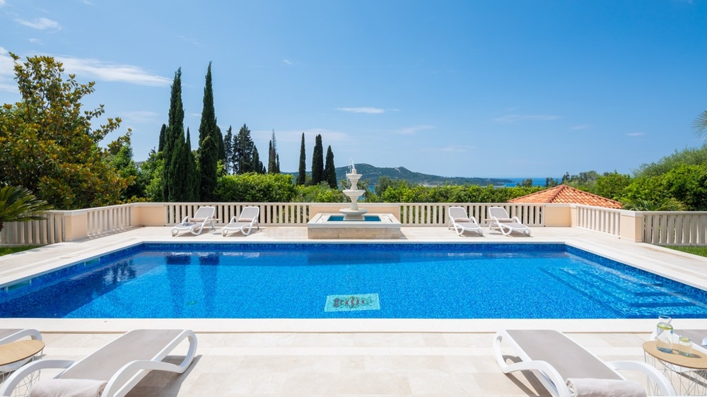 Terrazza della piscina con lettini e vista sul mare