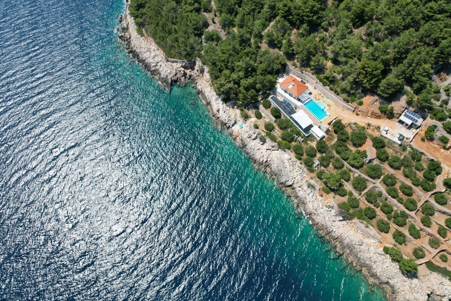 Vista aerea della casa con piscina in alto sulla costa rocciosa