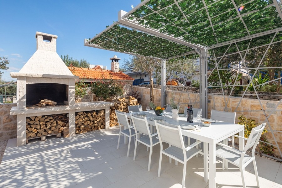 Cucina esterna con camino-grill e zona salotto coperta