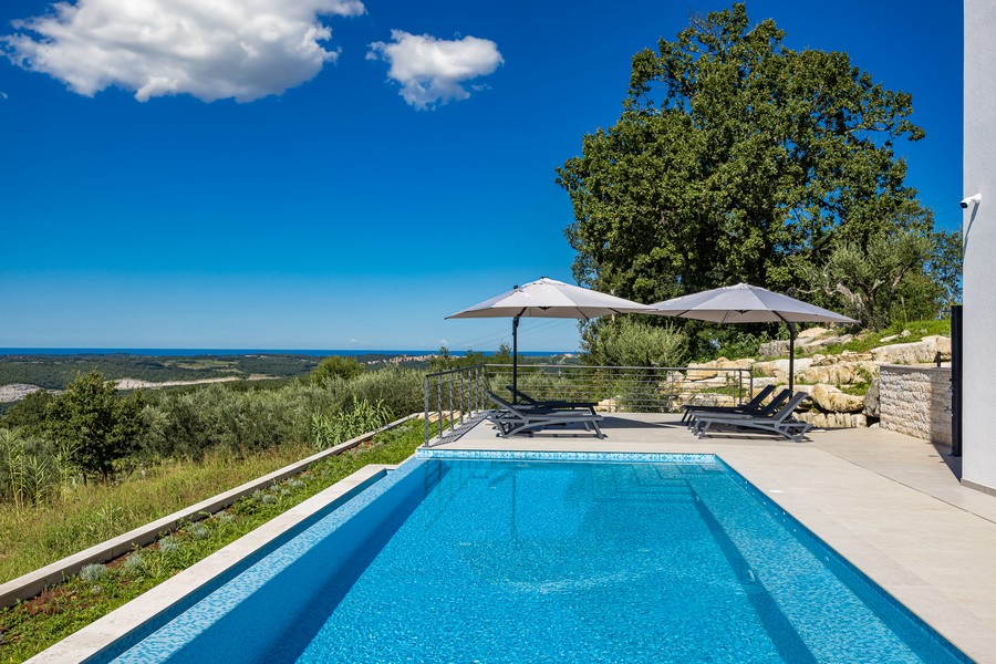 Ampia area piscina con terrazza solarium e vista mare