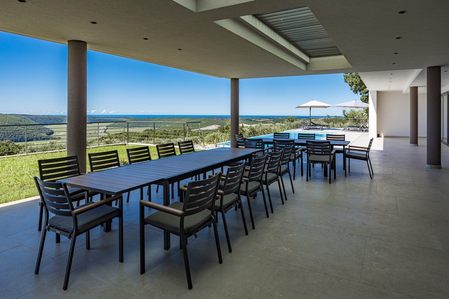 Terrazza coperta con grande tavolo da pranzo e vista ampia