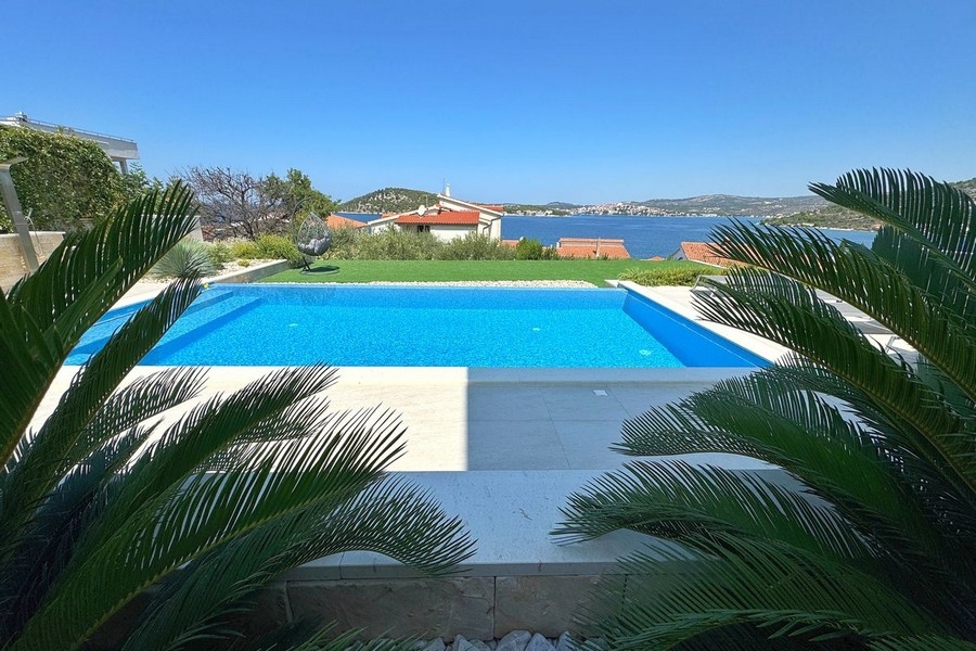 Piscina con terrazza solarium e vista sulla baia