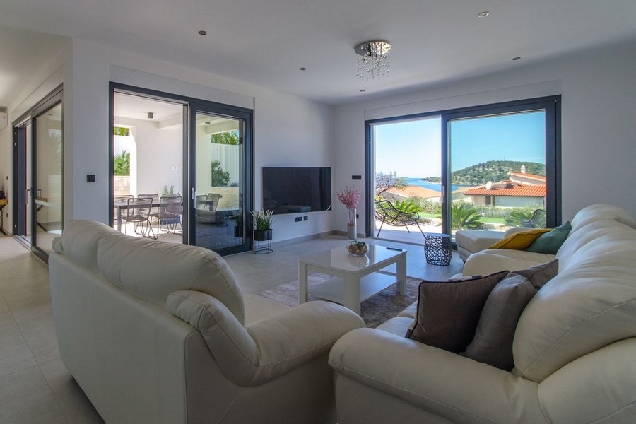 Zona giorno luminosa con grande vetrata e vista mare