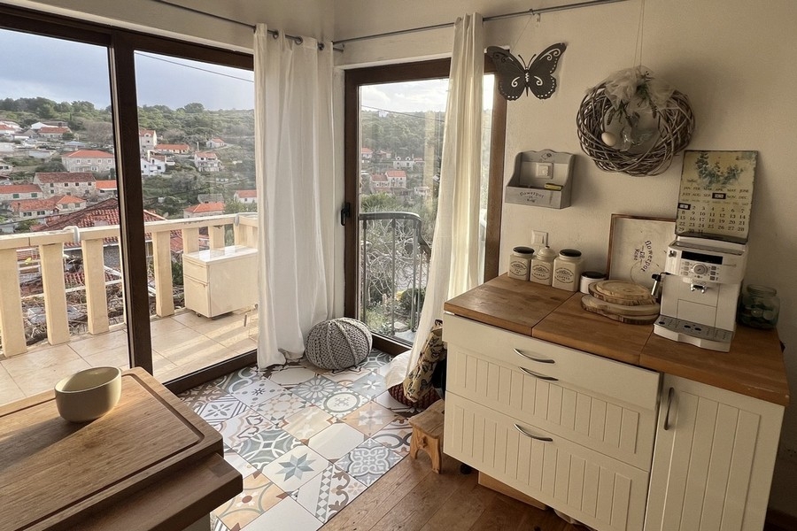 Angolo cucina con finestre a tutta altezza e accesso al balcone