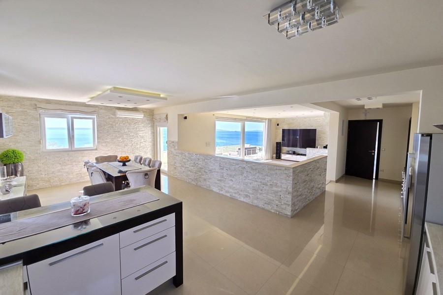 Zona giorno con zona pranzo e finestra panoramica sul mare