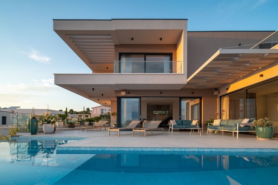 Villa con balconi a sbalzo e piscina nella luce della sera