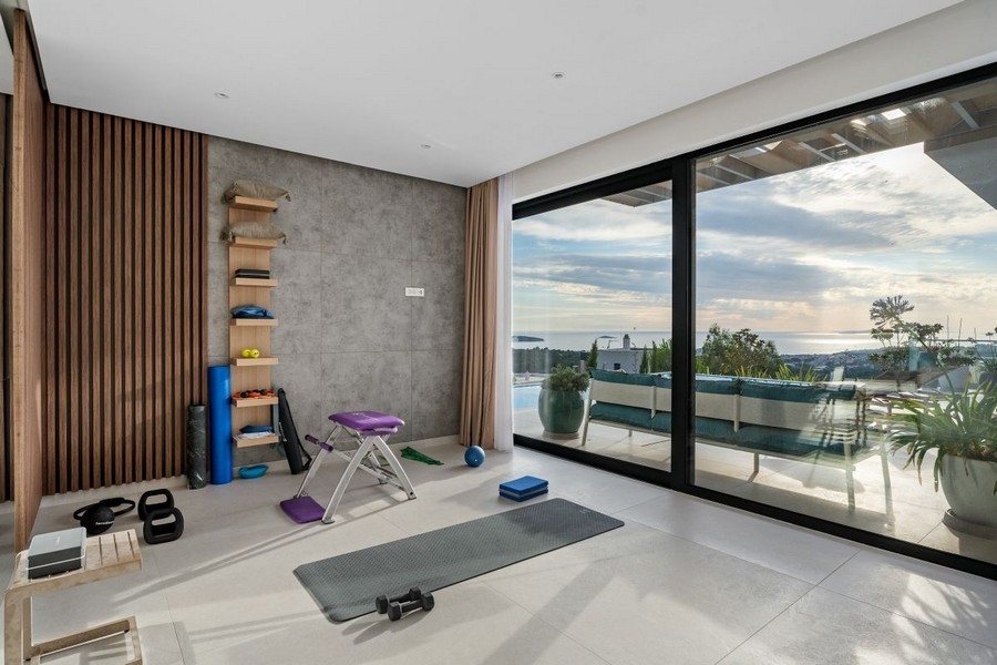 Sala fitness con grandi finestre e vista sul mare