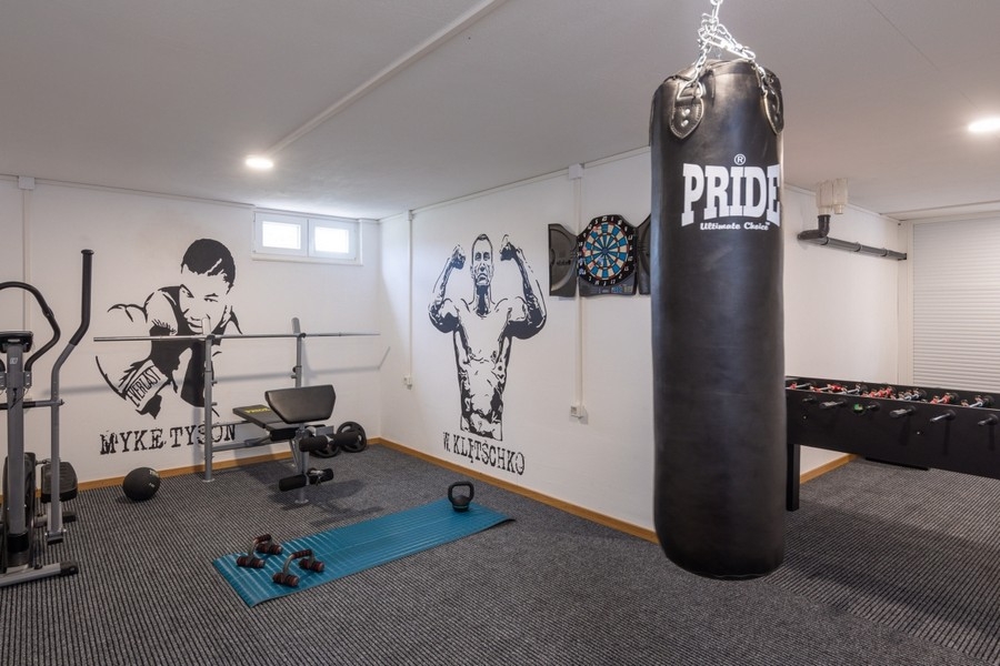 Sala fitness e hobby con sacco da boxe e attrezzi per l'allenamento