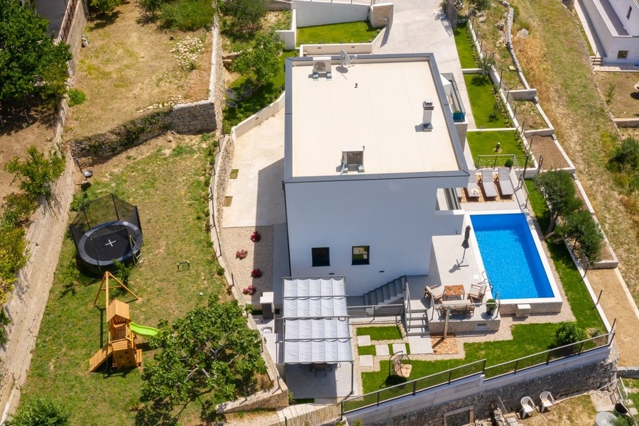 Veduta aerea della villa con piscina, giardino e parco giochi
