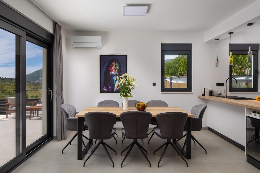 Zona pranzo con accesso alla terrazza e vista sul verde