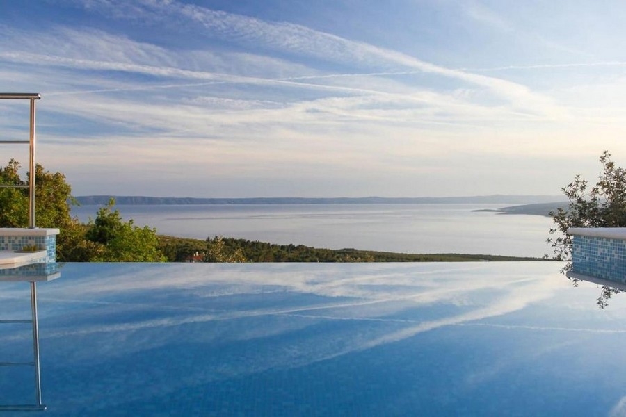 Piscina a sfioro con superficie a specchio sopra la baia