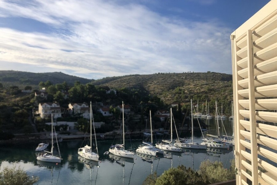 Vista mare dal balcone con barche a vela nella baia