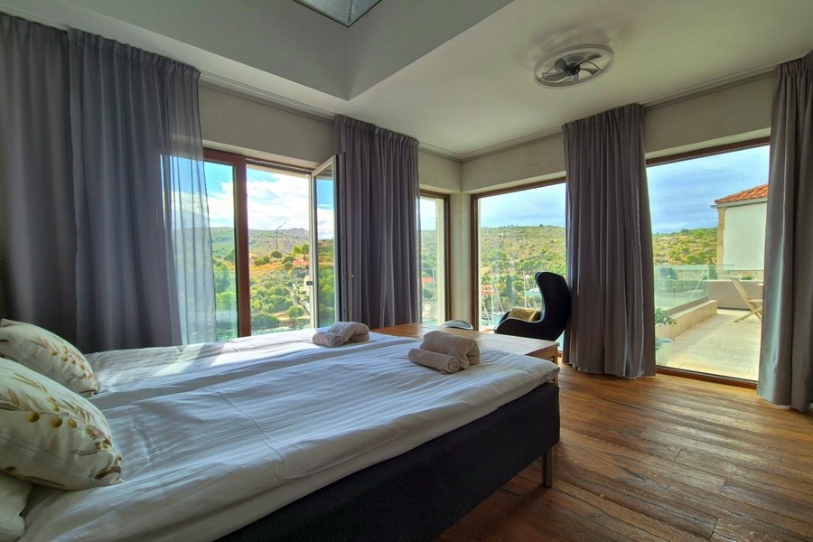 Camera da letto con finestre panoramiche e vista mare