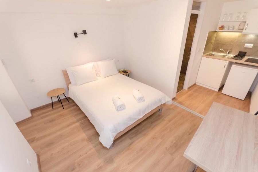 Zona notte con letto matrimoniale e angolo cucina nell'appartamento