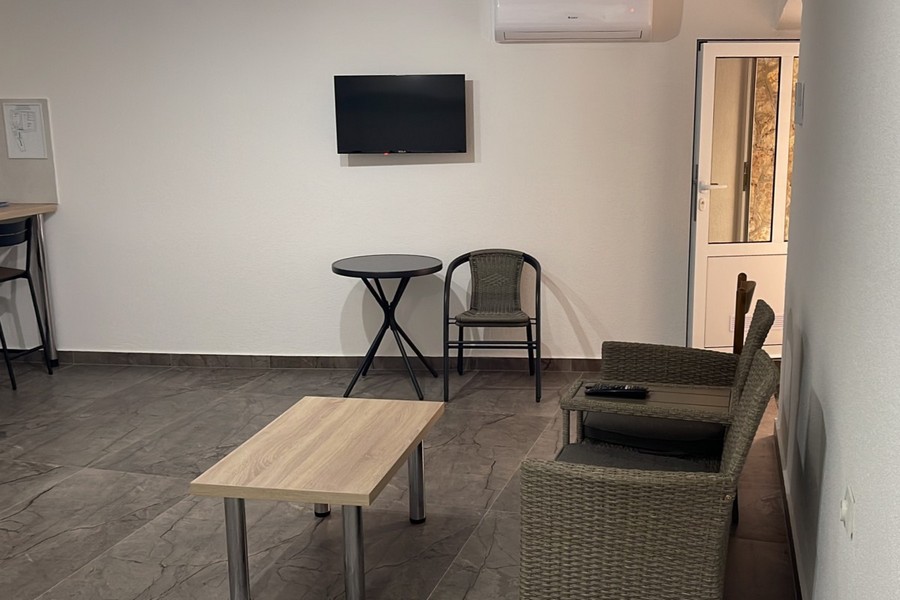 Zona giorno con poltrona e TV nell'appartamento in Croazia