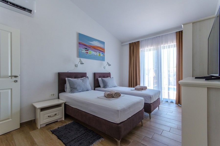 Camera da letto con due letti singoli e accesso al balcone
