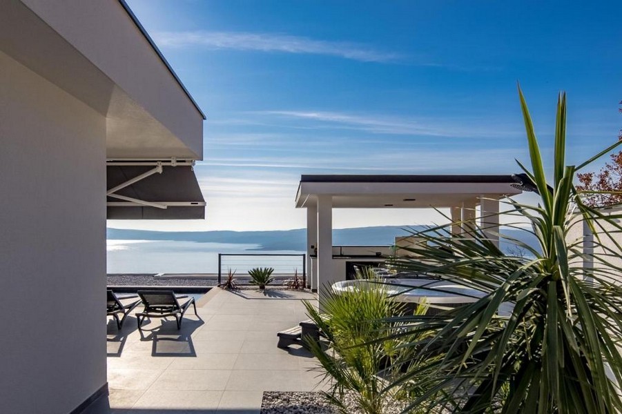 Terrazza con lettini e gazebo sopra la spiaggia di ghiaia