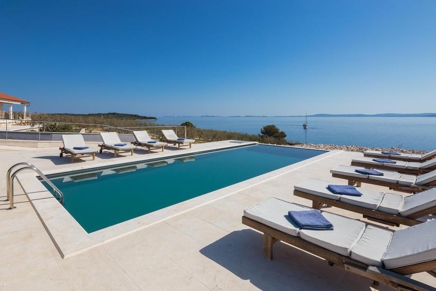 Piscina con terrazza solarium e vista sul mare