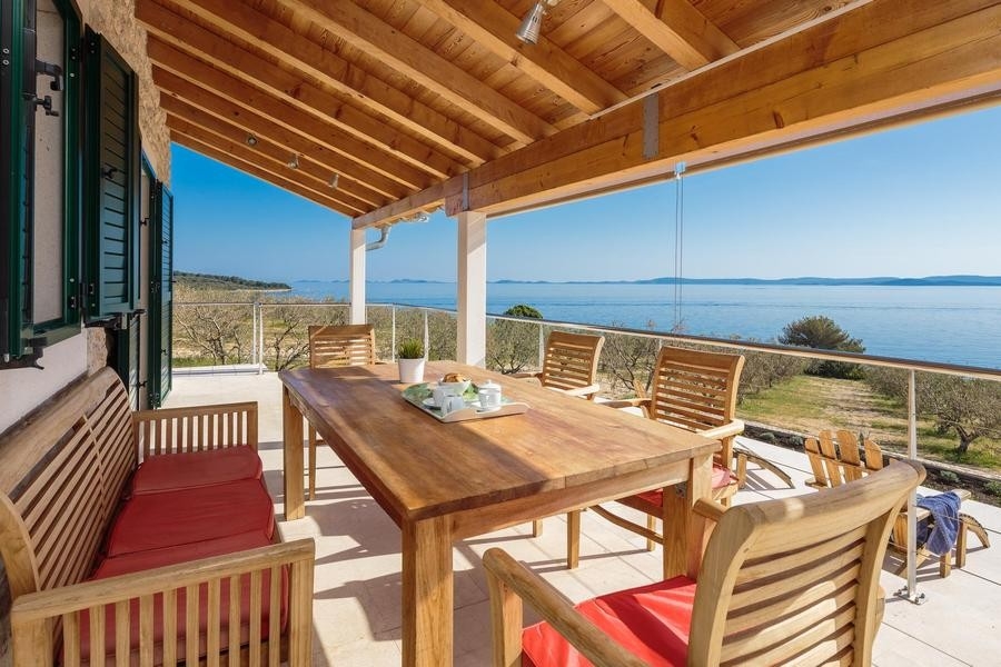 Terrazza coperta con tavolo e vista mare