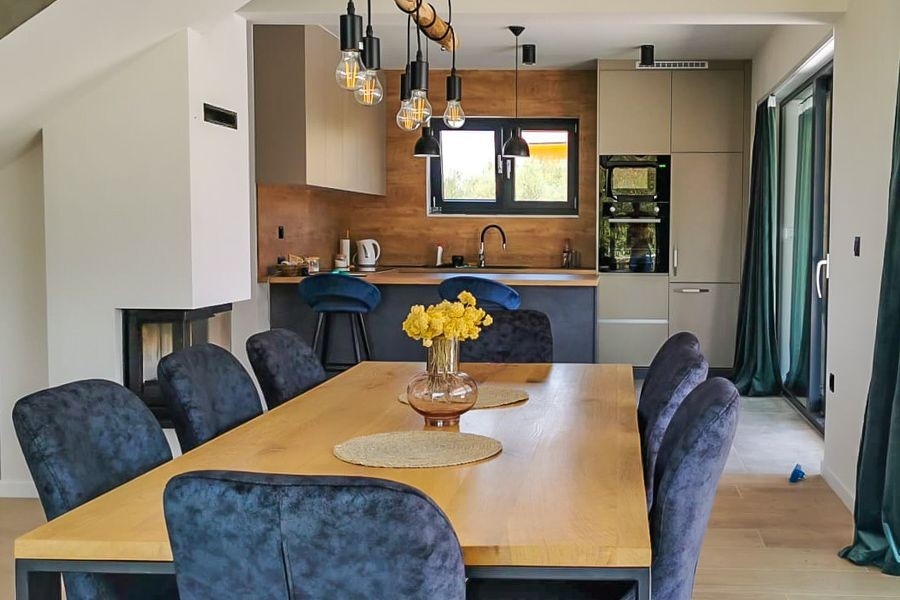 Zona giorno aperta con cucina e camino in una villa moderna