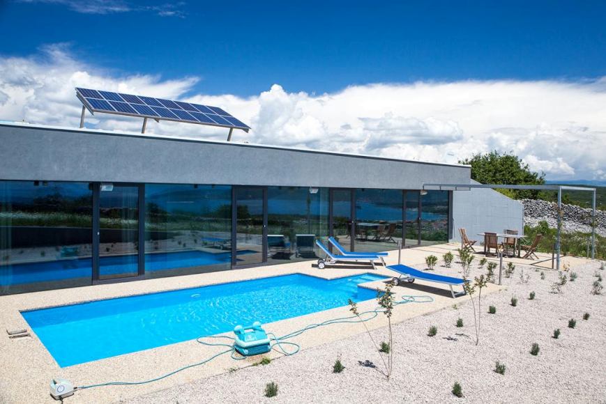 Villa con pannelli solari e piscina sulla superficie di ghiaia