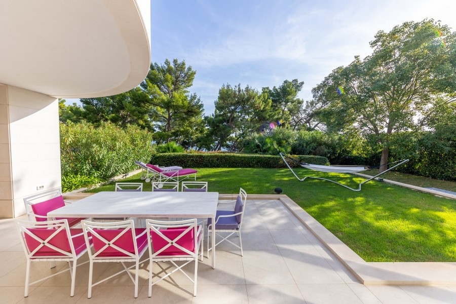 Terrazza con tavolo da pranzo e giardino curato della villa
