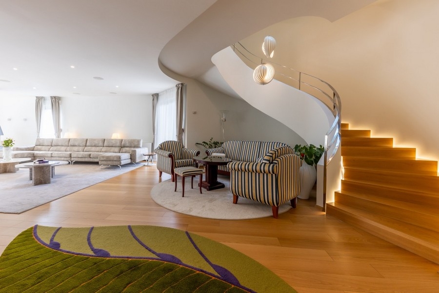 Elegante soggiorno con zona salotto e scala curva