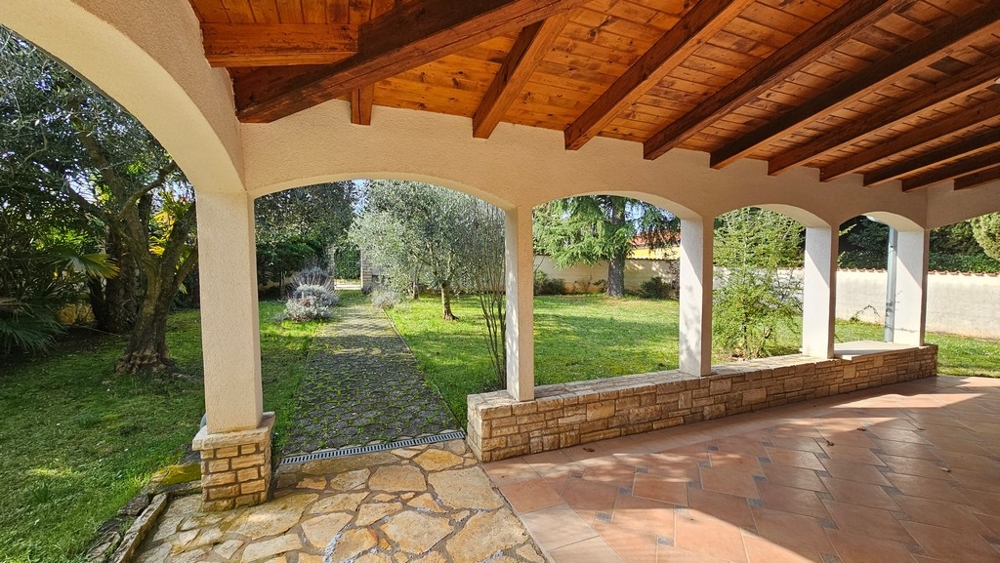 Terrazza coperta con salotto e vista sul giardino