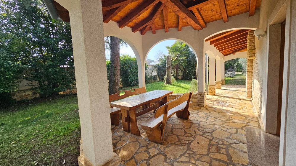 Grande terrazza coperta con giardino e arcate