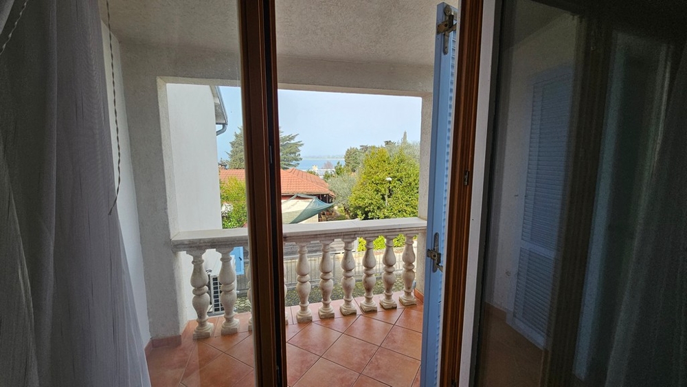 Balcone con vista sul giardino e sul mare