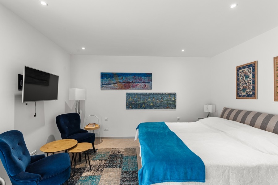Camera da letto con grande letto matrimoniale e zona salotto