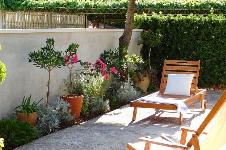 Terrazza con sdraio e piante mediterranee nel giardino