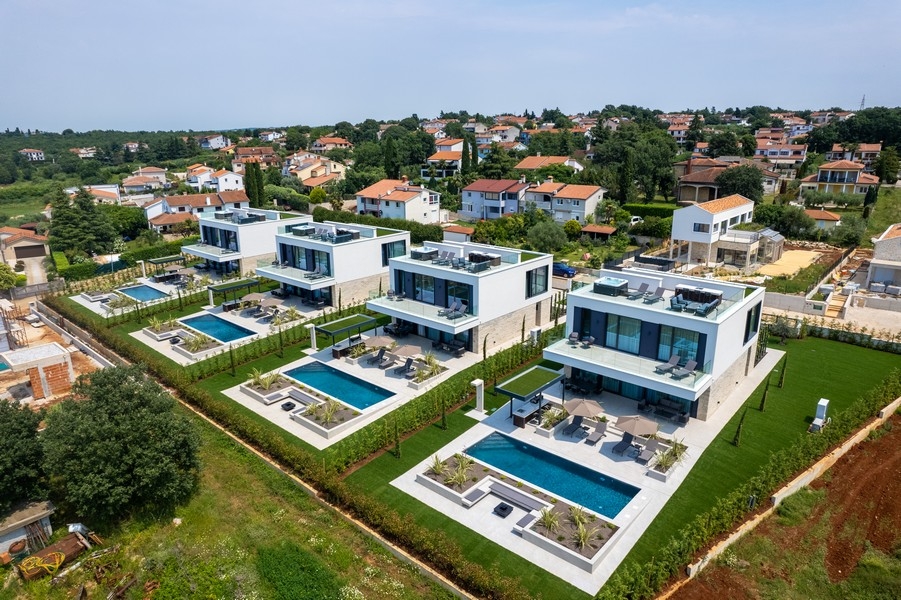 Vista aerea di più ville bianche con piscine private