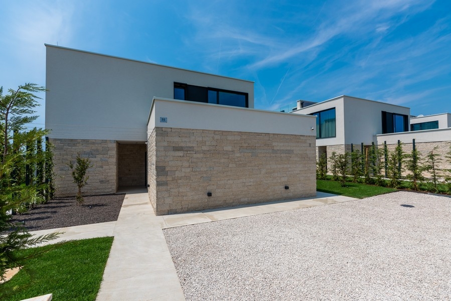 Villa moderna con facciata in pietra naturale e posti auto