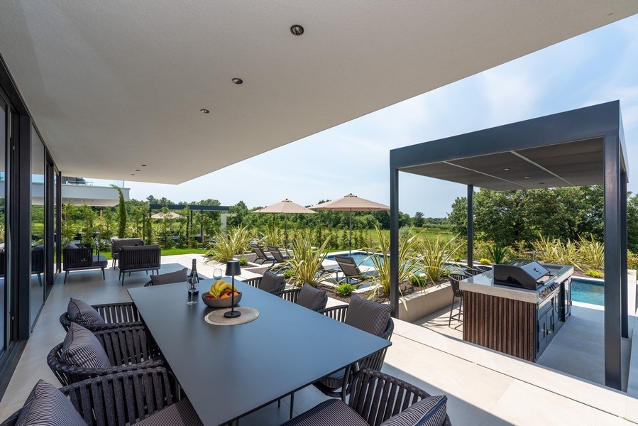 Terrazza coperta con zona pranzo e cucina esterna a bordo piscina