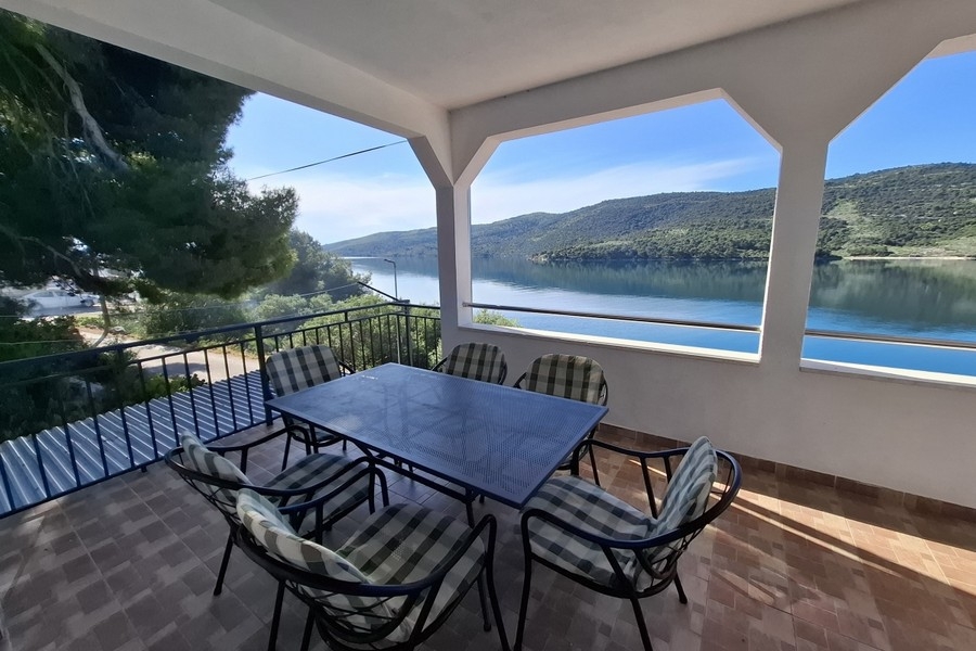 Area esterna coperta con tavolo da pranzo e vista sul mare