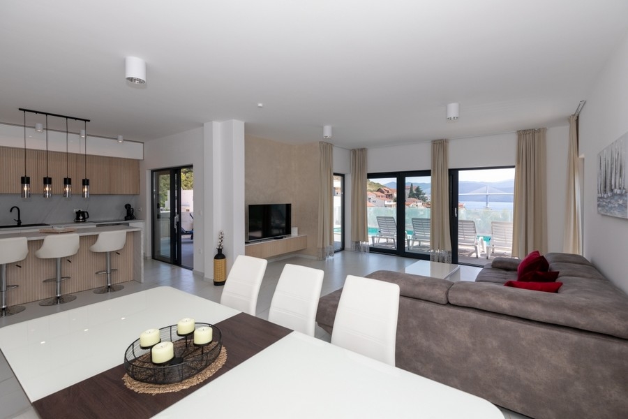 Zona giorno aperta con cucina e vista mare dalle grandi finestre