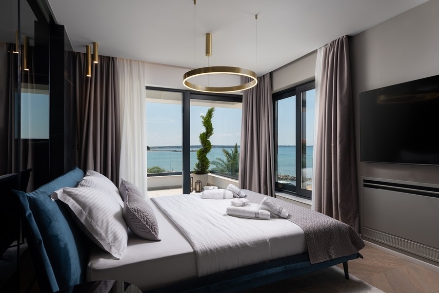 Camera da letto con grandi finestre e vista mare in Croazia