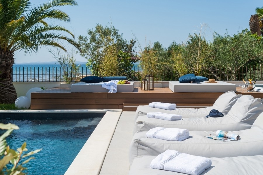 Area piscina con terrazza solarium e vista mare presso una villa moderna