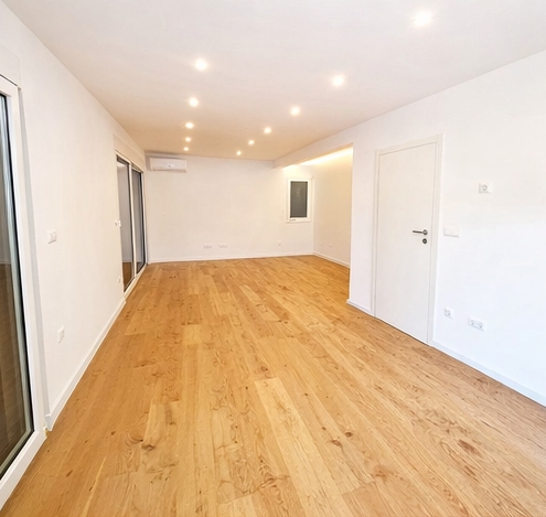 Soggiorno luminoso con parquet e grandi superfici vetrate